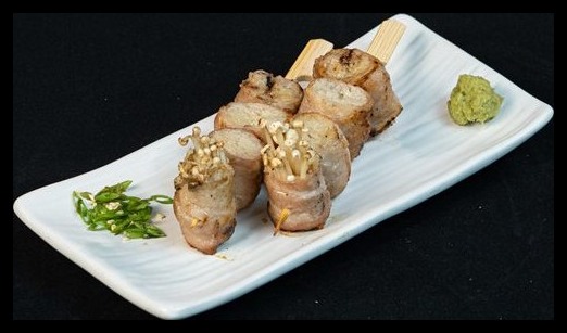 Grilled yakitori skewers on a white plate